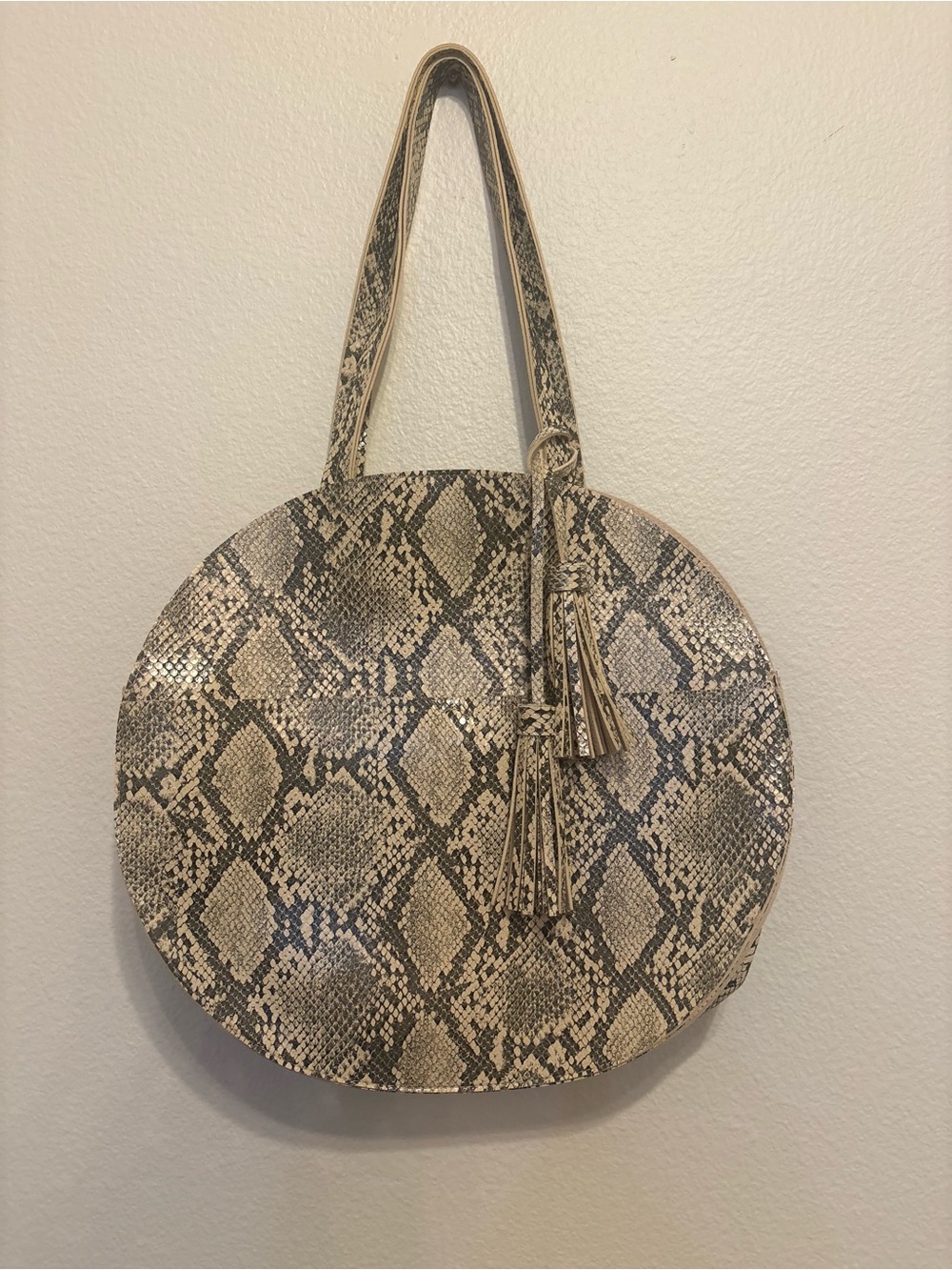 Chic round circular tote bag featuring a neutral gray and cream snakeskin/python